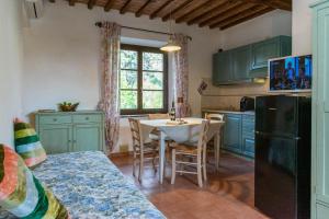 a kitchen with a table and a black refrigerator at Residence La Casaccia in Venturina Terme