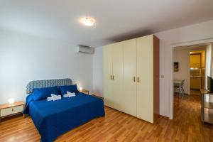 a bedroom with a blue bed and a white cabinet at Sun Palace Residence in Premantura