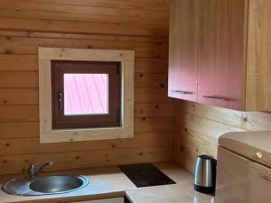 a kitchen with a sink and a small window at POD FALAMI - domki letniskowe in Polańczyk +45 photos