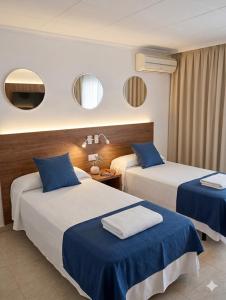 a hotel room with two beds with blue sheets at Hotel Iberflat Marynton in Benicarló