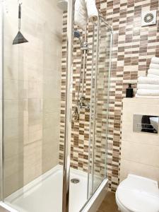 a bathroom with a shower and a toilet at Holidays Summer Vibes Apart Mamaia Nord in Năvodari +30 photos