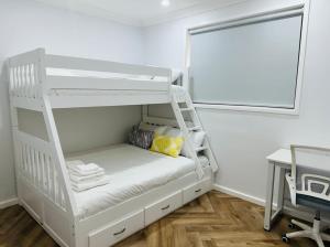 a white bunk bed in a room with a window at Resort-style living -pool in Bass Hill