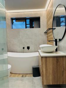a bathroom with a tub and a sink and a mirror at Resort-style living -pool in Bass Hill +7 photos