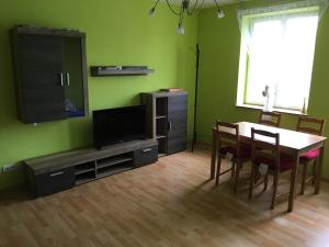 a living room with a table and a television and a table and chairs at City Apartment Děčín in Děčín +7 photos