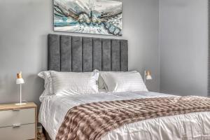 a bedroom with a bed with a gray headboard at The Link Sandton Apartment in Johannesburg