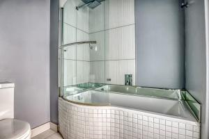 a bath tub in a bathroom with a toilet at The Link Sandton Apartment in Johannesburg +27 photos