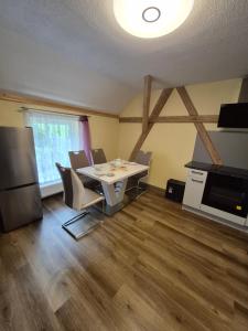 a dining room with a table and chairs and a refrigerator at Pension am Lindenbaum in Kirnitzschtal