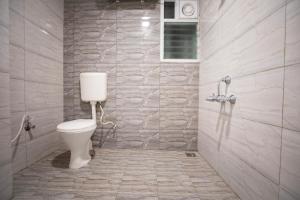 a bathroom with a white toilet in a room at Z Express Anoop in Bangalore +2 photos