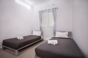 two beds in a room with white walls at Z Express Anoop in Bangalore