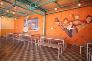 a restaurant with tables and a mural on the wall at Z Express Anoop in Bangalore