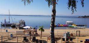 a beach with a pier and boats in the water at LeśnyZakątekNysa in Skorochow