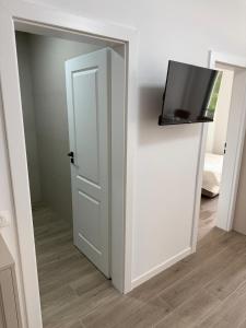 a white door with a tv on top of it at Aria & Boris Apart Kogalniceanu in Oradea