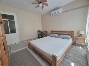 a bedroom with a large bed and a fan at Teraslı Müstakil Ev in Cunda
