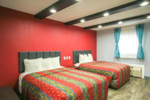 two beds in a room with red walls at Marshall Lodge By OYO Hwy 65 in Marshall
