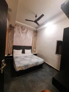 a bedroom with a bed and a ceiling fan at VT residency in Tājganj
