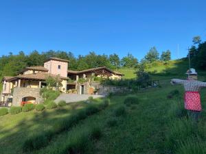 a woman standing in a field in front of a house at Podere Caselina b&b in Camugnano