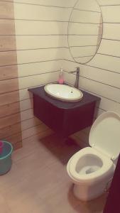 a bathroom with a sink and a toilet and a mirror at VT residency in Tājganj
