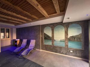 a room with purple chairs and a painting on the wall at epOche Hotel 1889 in Nago-Torbole