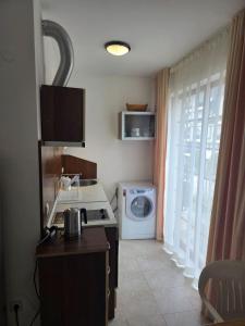 a kitchen with a stove and a washing machine at Морски Фар in Sveti Vlas