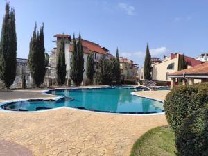 a large swimming pool with trees and buildings at Морски Фар in Sveti Vlas