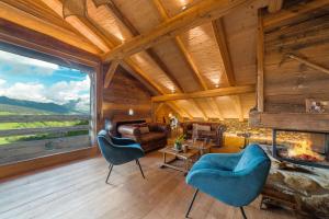a living room with a fireplace and a large window at La Ferme 1828 in Demi-Quartier