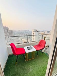 a balcony with two chairs and a table with a view at THE CITYLIGHTS STAY Gaur City Mall in Ghaziabad