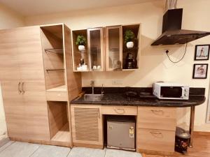 a kitchen with a sink and a counter top at THE CITYLIGHTS STAY Gaur City Mall in Ghaziabad