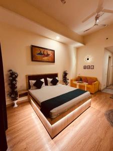 a bedroom with a large bed and a couch at THE CITYLIGHTS STAY Gaur City Mall in Ghaziabad +22 photos