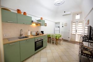a kitchen with green cabinets and a table in it at Dimora del Murattiano in Monopoli