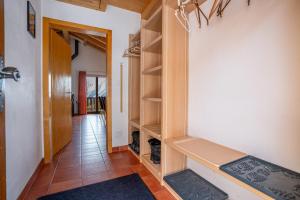 a hallway with a walk in closet with wooden shelves at Chalet UVA in Bettmeralp