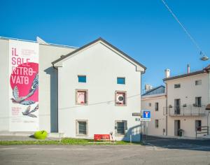 a white building with a red bench in front of it at Bastian B&B in Sarmede