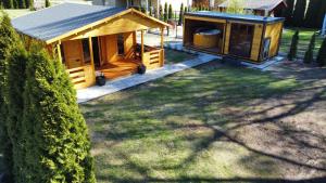 a large wooden cabin in the yard of a house at Zacisze domek z Jacuzzi & Sauna in Chrołowice