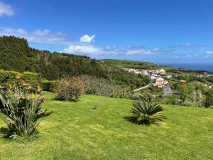 a field of green grass with houses on a hill at CasaBelaVista II in Pedreira