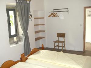 a bedroom with a bed and a window and a chair at CasaBelaVista II in Pedreira
