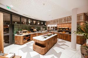 a large kitchen with wooden cabinets and counters at ibis Budget Luxembourg Aeroport in Luxembourg