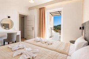 a bedroom with a bed and a desk and a window at Villa Dimi in Tsilivi +23 photos