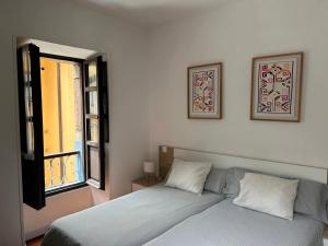 a bedroom with a bed and a window at Apartamento Manuel Cue en el centro de Llanes in Llanes