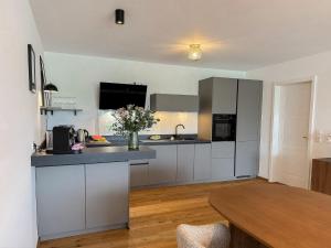 a kitchen with white cabinets and a wooden table at Ferienwohnung Uferchalet am Dümmer See in Lembruch