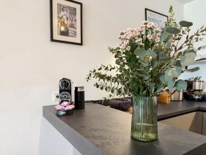 a vase of flowers sitting on a counter with a table at Ferienwohnung Uferchalet am Dümmer See in Lembruch +20 photos