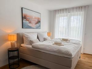 a large white bed in a bedroom with a window at Ferienwohnung Uferchalet am Dümmer See in Lembruch