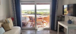 a living room with a table and chairs and a balcony at Sardegna Top Golfo Di Marinella in Golfo Aranci