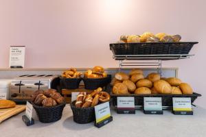 a bunch of baskets of bread and pastries on a counter at Hotel Continental Frankfurt in Frankfurt