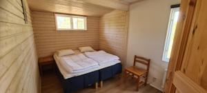 a small room with a bed and a chair in it at Röksvamp 1 in Västra Stensjö