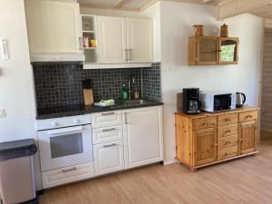 a kitchen with white cabinets and a stove top oven at Röksvamp 1 in Västra Stensjö