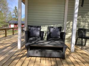 a wicker chair on a porch with a table at Röksvamp 1 in Västra Stensjö +13 photos