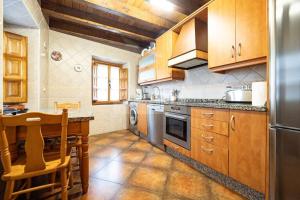 a kitchen with wooden cabinets and a table in it at Fuente Buelna By Silastur in Buelna