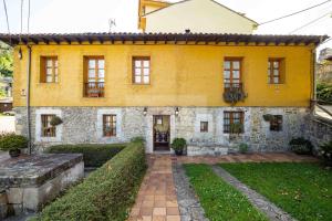 a yellow house with a garden in front of it at Fuente Buelna By Silastur in Buelna