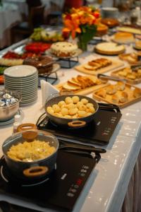 a buffet of food with bowls of food on a table at Biazi Plaza Hotel Bauru in Bauru