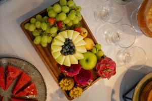 a tray of fruit on a table with wine glasses at Biazi Plaza Hotel Bauru in Bauru