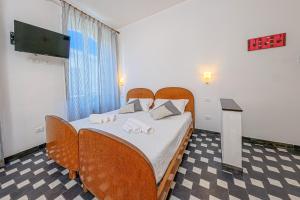 ein Schlafzimmer mit einem Bett mit Stühlen und einem Fernseher in der Unterkunft Da Tallolo in Cagliari